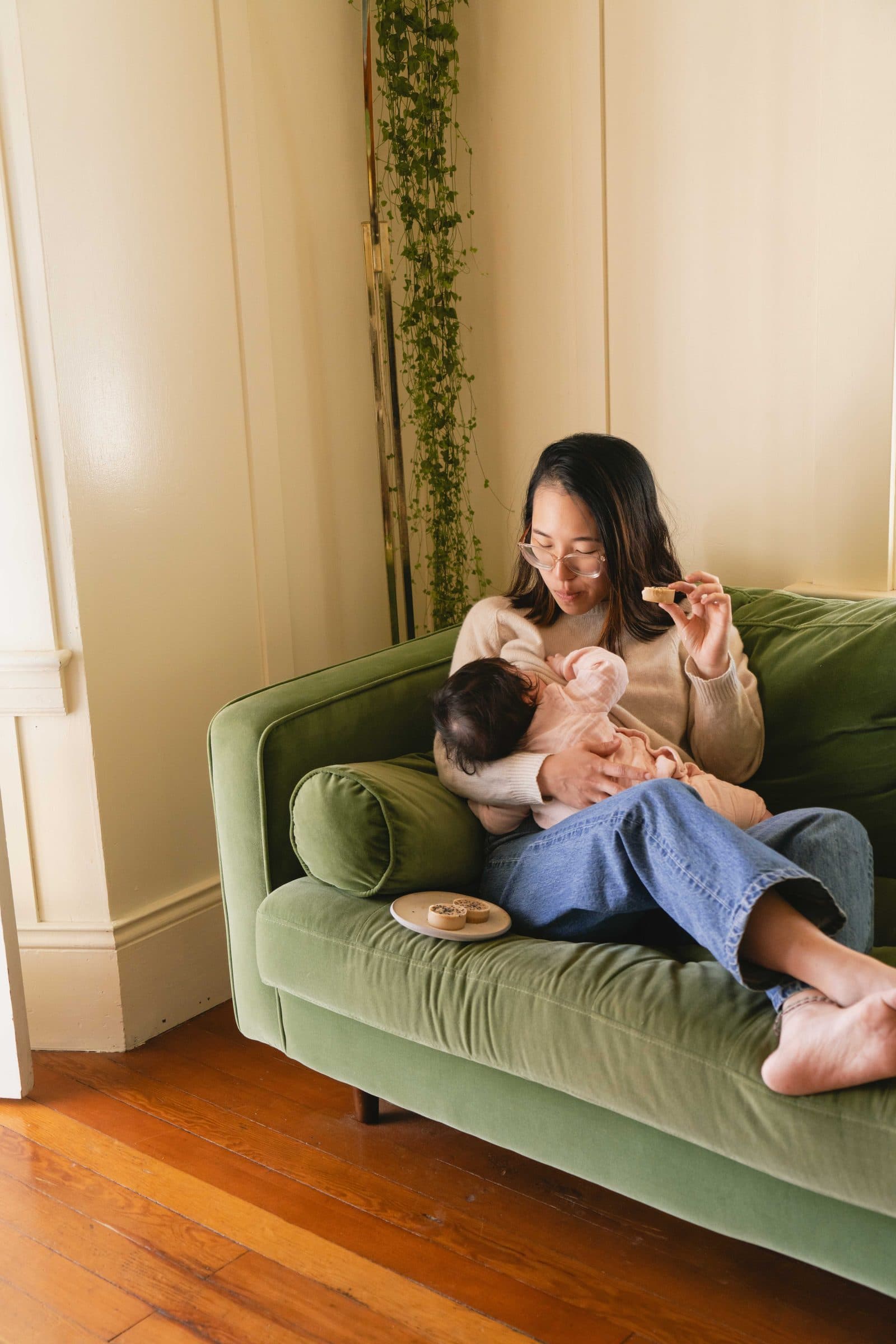 A mother enjoying a Snacktation while holding her baby